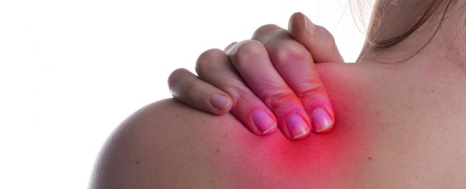 A woman hold her shoulder in pain. The area on the shoulder is higlighted to symbolize the pain.