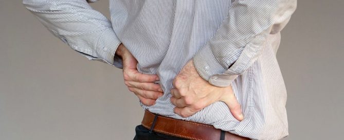 A young man suffering from back pain.
